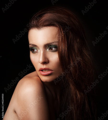 Beautiful young woman with makeup in a studio posing