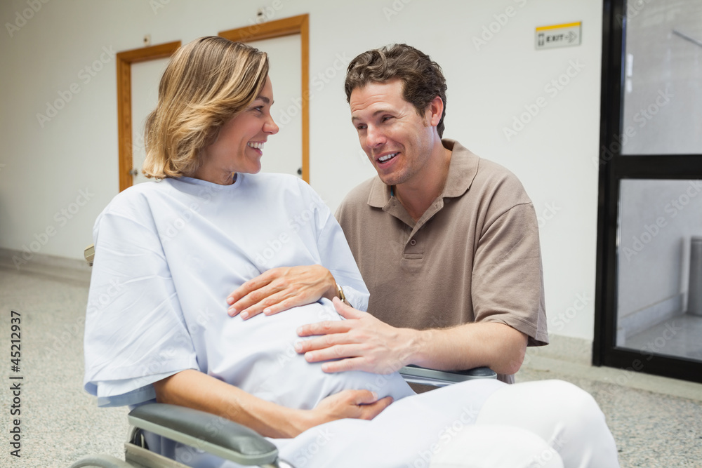 Pregnant woman in wheelchair talking with partner Pregnant woman in wheelchair talking with partner