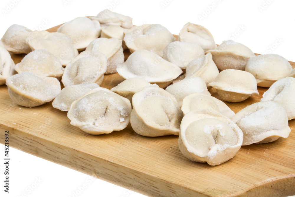 Some raw dumplings on the wooden board Some raw dumplings on the wooden board