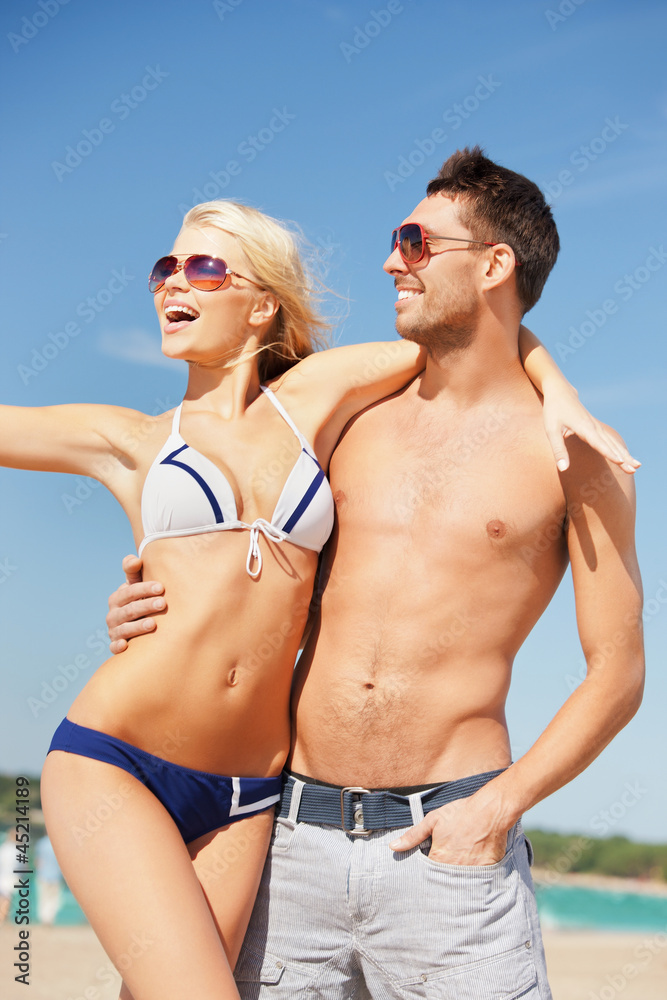happy couple in sunglasses on the beach happy couple in sunglasses on the beach