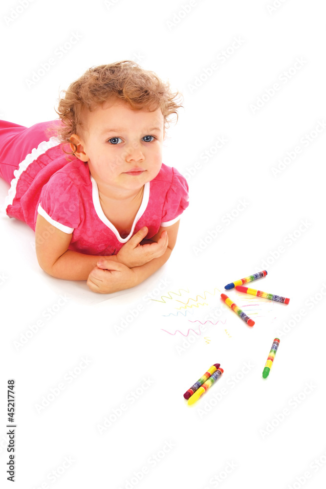 A lovely child with pencils lying on the floor A lovely child with pencils lying on the floor