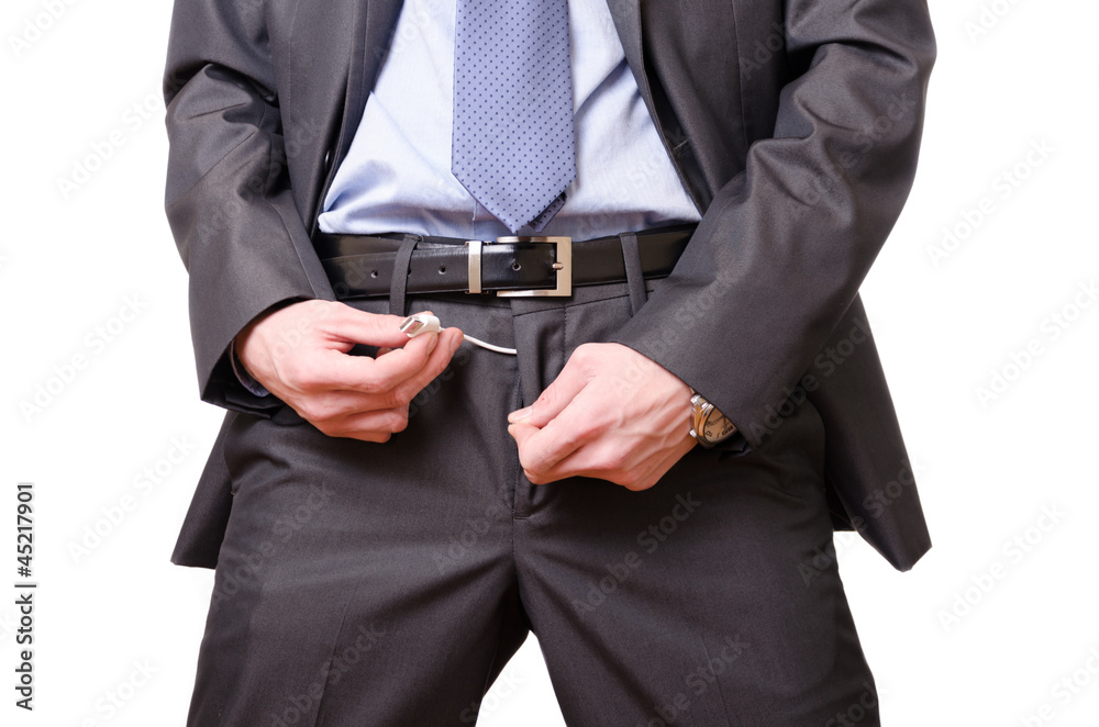 Young businessman mockingly pulling a usb cable off his pants. Stock Photo