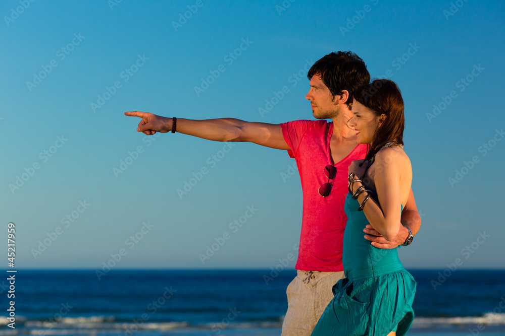 Mann und Frau genießen Sonnenuntergang am Strand Mann und Frau genießen Sonnenuntergang am Strand