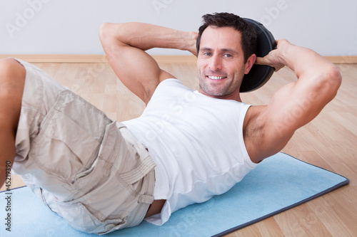 Young Man Exercising On Exercise Mat