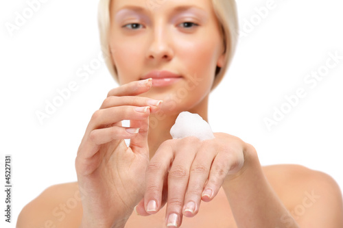 A beautiful woman with cream in her hand  focus on her hand