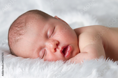 Sleeping newborn baby asleep on fluffy blanket