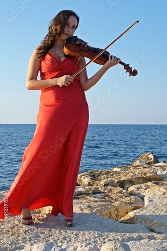 Musicista con violino al mare photo