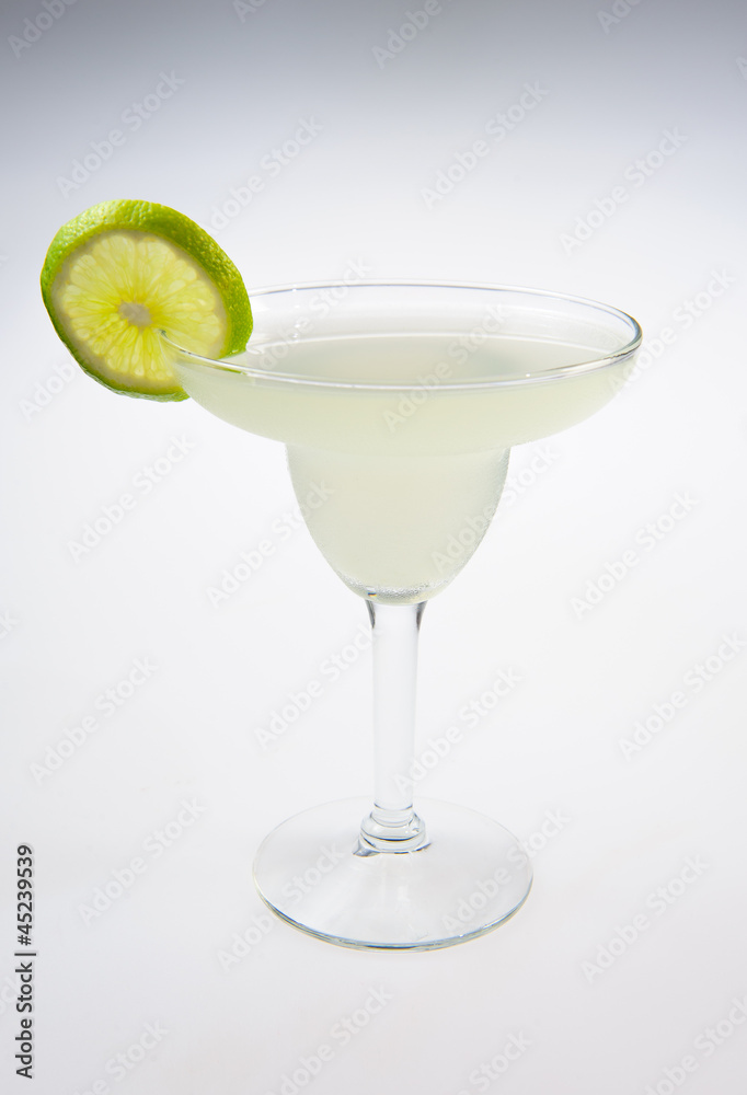 Alcohol cocktail with lime over white background