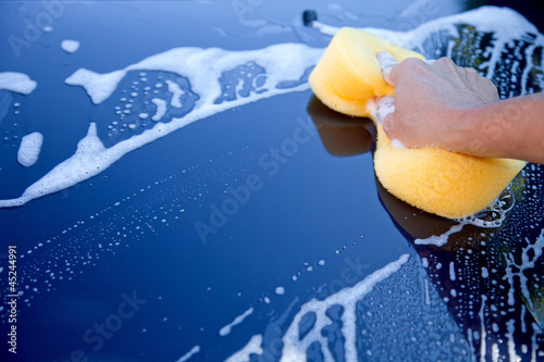 hand hold sponge over the car for washing