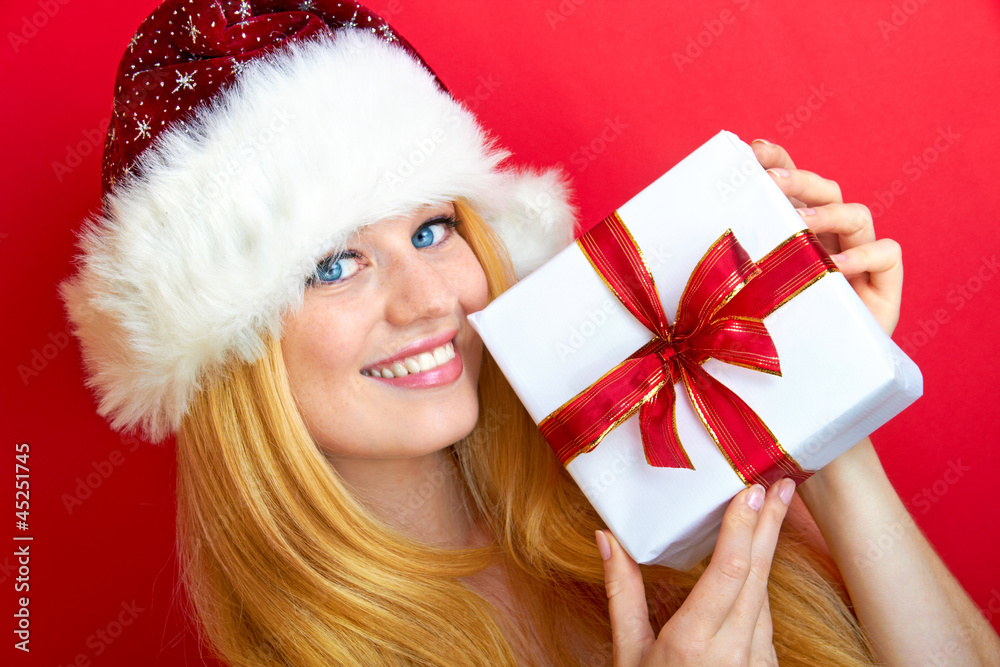 portrait of blonde woman holding a christmas gift is smiling portrait of blonde woman holding a christmas gift is smiling