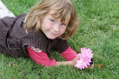 oitdoor portrait of young cute child girl relaxing on green gras photo