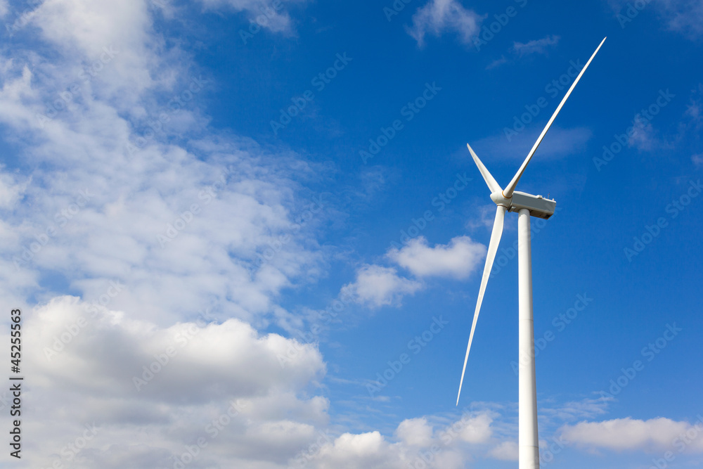 White wind turbine generating electricity on cloudy sky White wind turbine generating electricity on cloudy sky