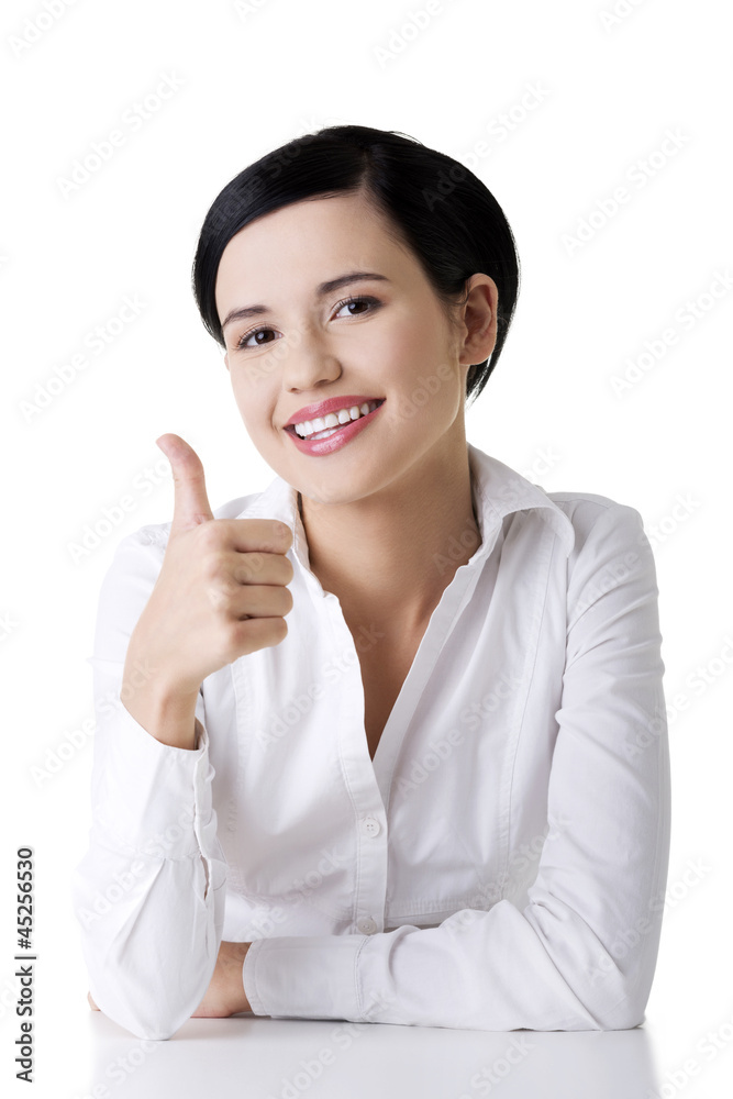 Young woman at the desk gesturing OK Young woman at the desk gesturing OK