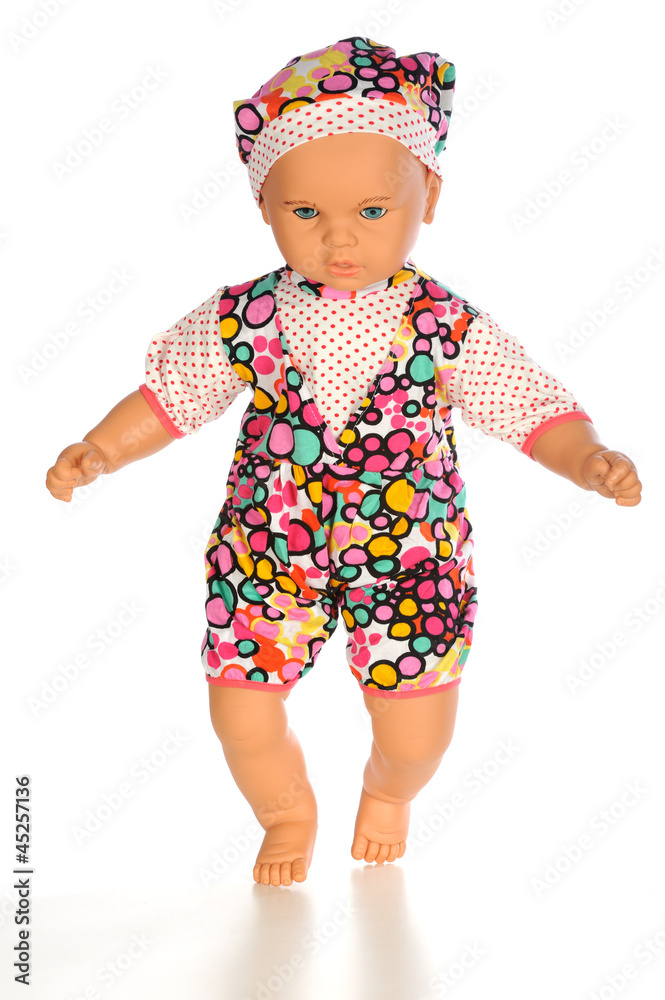 Baby doll with color dress standing isolated white bacground Baby doll with color dress standing isolated white bacground