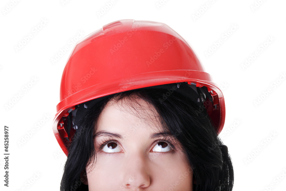 Confident female worker in helmet looking up Confident female worker in helmet looking up