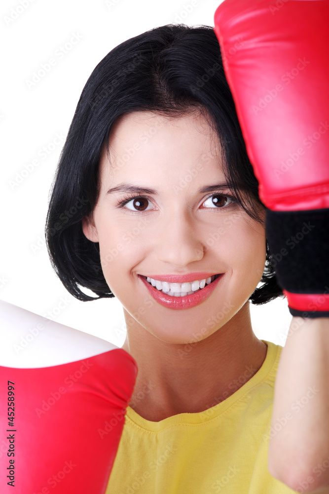 Young woman wearing a pair of boxing gloves. Young woman wearing a pair of boxing gloves.