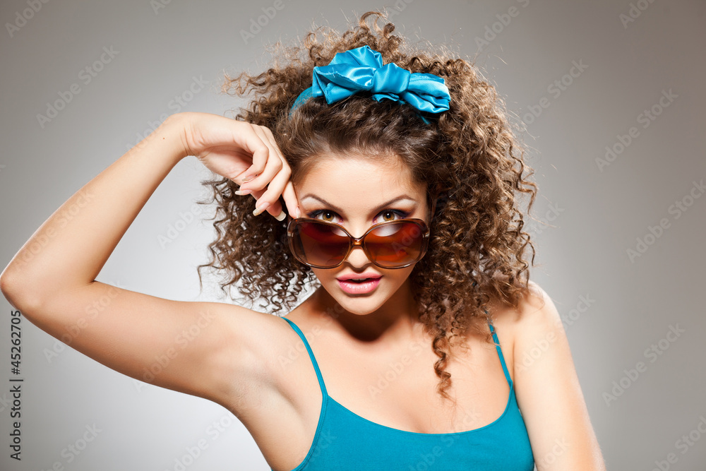 Fototapeta premium pretty girl with curly hair wearing sunglasses