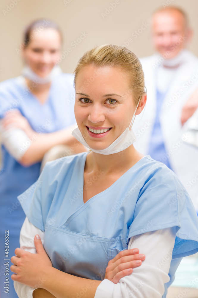 Fototapeta premium Smiling female dentist surgeon with colleagues