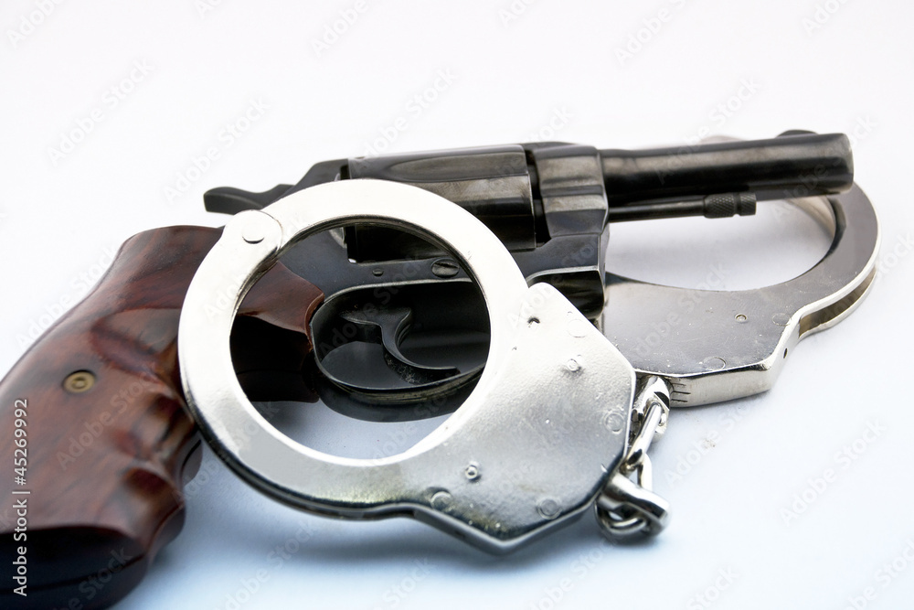 Obraz premium handgun revolver and police handcuff on white background