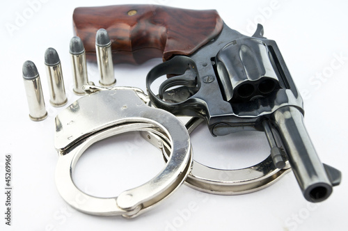 Fototapeta handgun revolver and police handcuff with bullets on white backg
