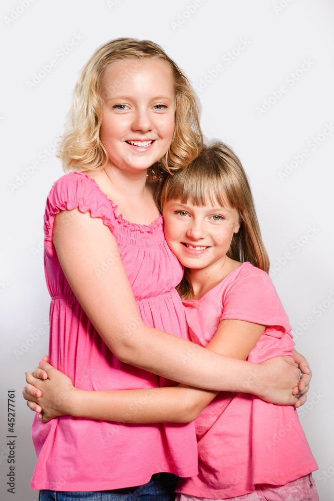 two cheerful preteen girls hugging as best friends two cheerful preteen girls hugging as best friends