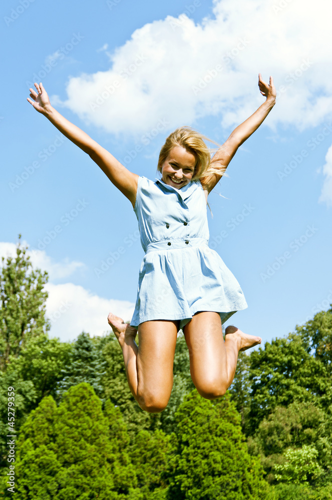 Beautiful young woman jump up to the sky in park Beautiful young woman jump up to the sky in park