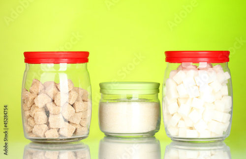 Jars with brown cane sugar lump, white crystal sugar and white