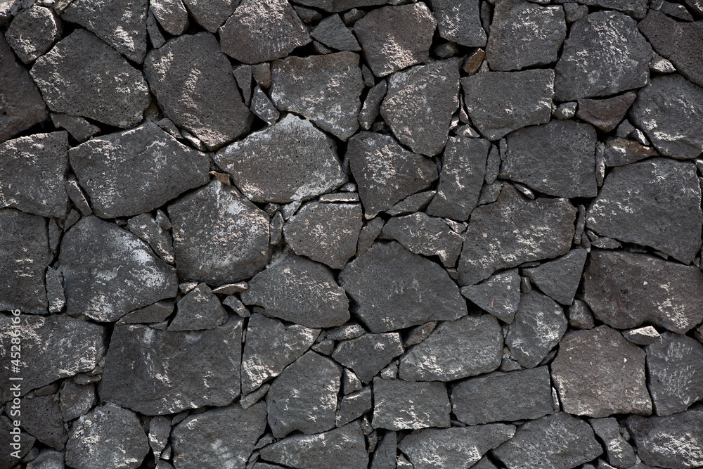 Black lava stone volcanic masonry wall Black lava stone volcanic masonry wall