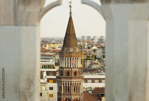An old medieval tower inside a frame over the milan cathedral
