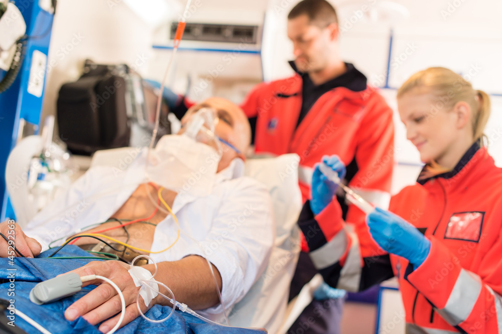 Sick patient with paramedic in ambulance treatment
