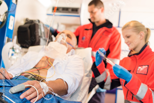 Obraz na płótnie Sick patient with paramedic in ambulance treatment w salonie