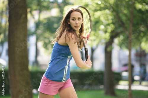 Junge Frau spielt Tennis photo