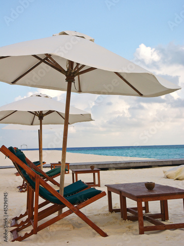 Beach chair and umbrella on idyllic tropical sand beach