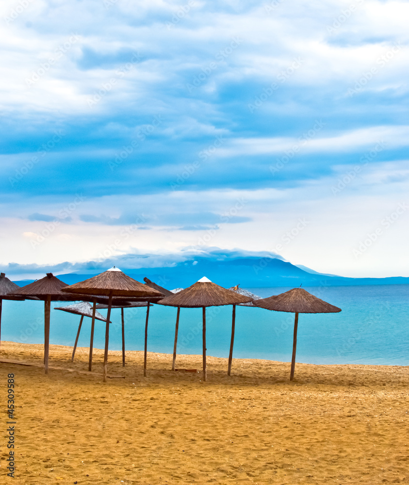A straw umbrella on a tropical beach with blue sky A straw umbrella on a tropical beach with blue sky