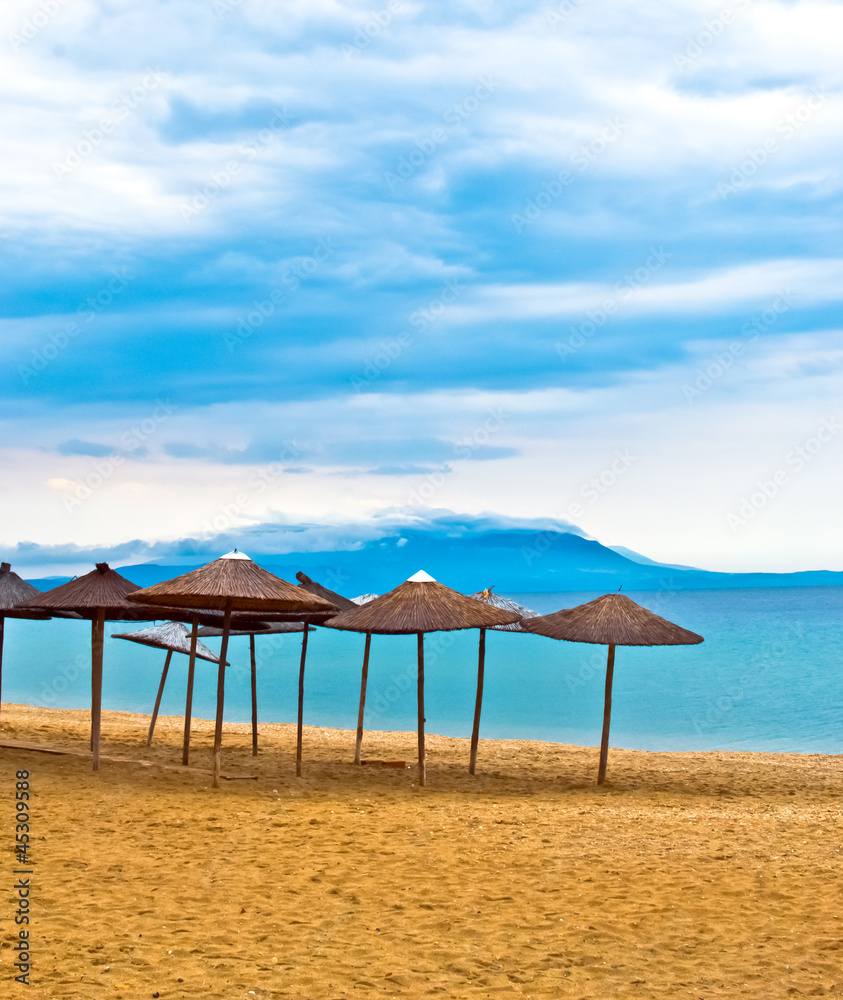 A straw umbrella on a tropical beach with blue sky