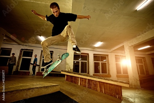 Young man performing a stunt in a skatepark