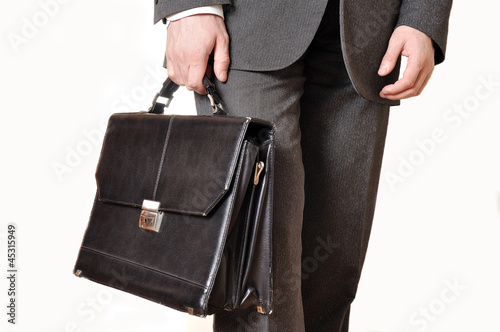 Shabby black leather briefcase in male hand