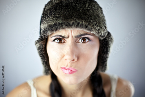Piękna kobieta w czapce ze skrzywionymi ustami