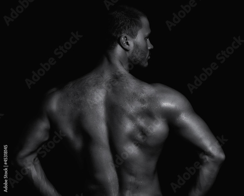 Rear view of young muscular man. Black and white