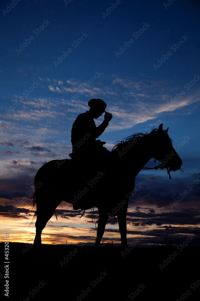 Cowboy holding hat horse sunset