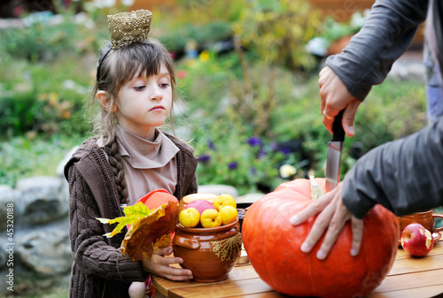 Little girl watching the carvin of pumpkin photo