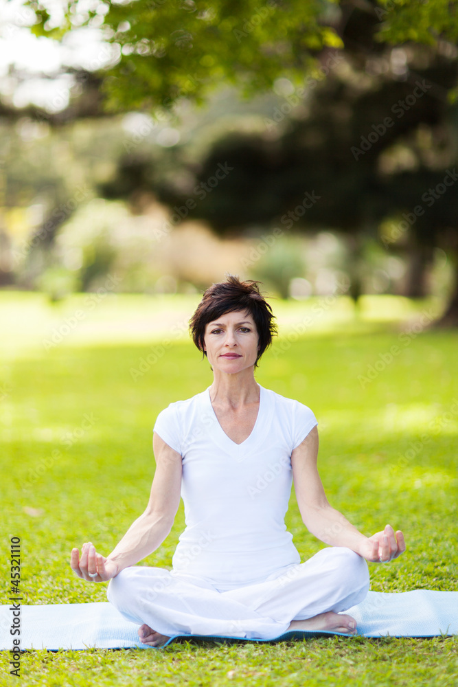 middle aged woman doing yoga meditation outdoors middle aged woman doing yoga meditation outdoors
