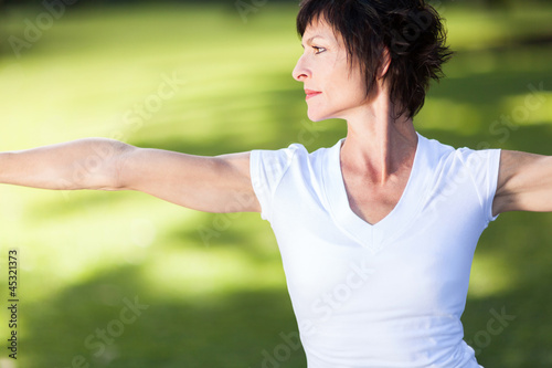 middle aged woman doing exercise outdoors