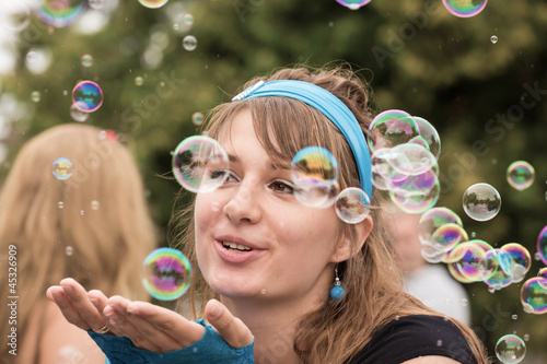 The young woman among soap bubbles