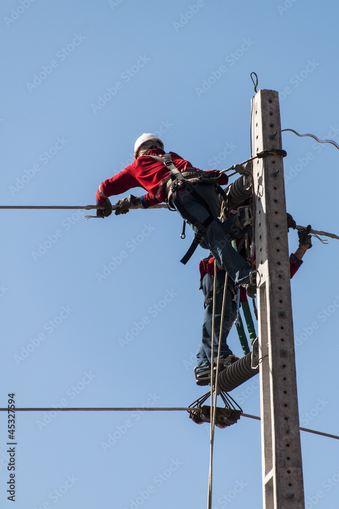 Electricians working on a pylon Electricians working on a pylon