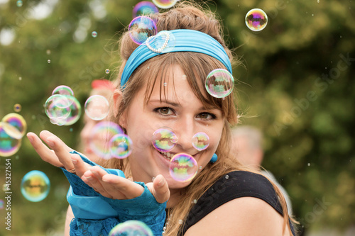 The young woman among soap bubbles