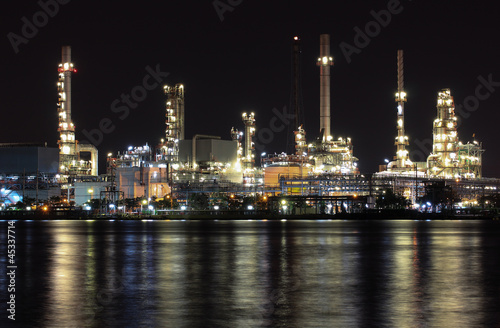 Oil refinery plant night scene nearby river in Thailand