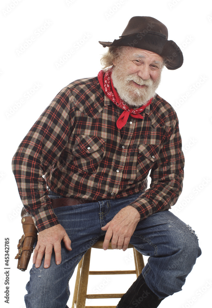 Cheerful old cowboy sits on a stool Cheerful old cowboy sits on a stool