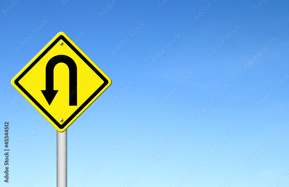 Yellow warning sign u-turn roadsign with blue sky background Yellow warning sign u-turn roadsign with blue sky background