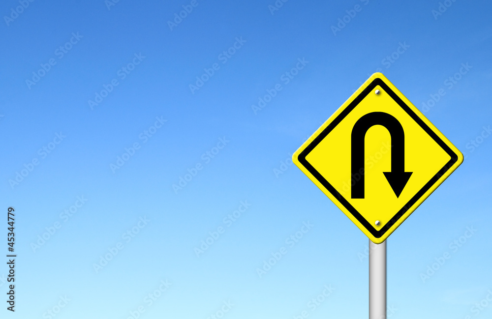 Yellow warning sign u-turn roadsign with blue sky background Yellow warning sign u-turn roadsign with blue sky background
